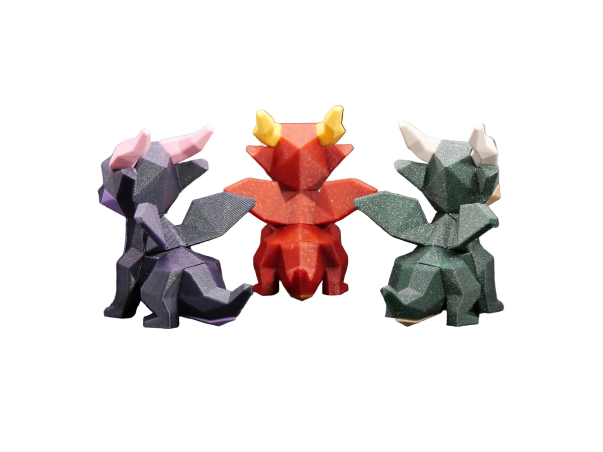 Three low-poly dragon figurines in purple, red, and green, displayed on a dark surface with a black background. The brand name 'Thanabun Lab' is visible as an overlay at the bottom.